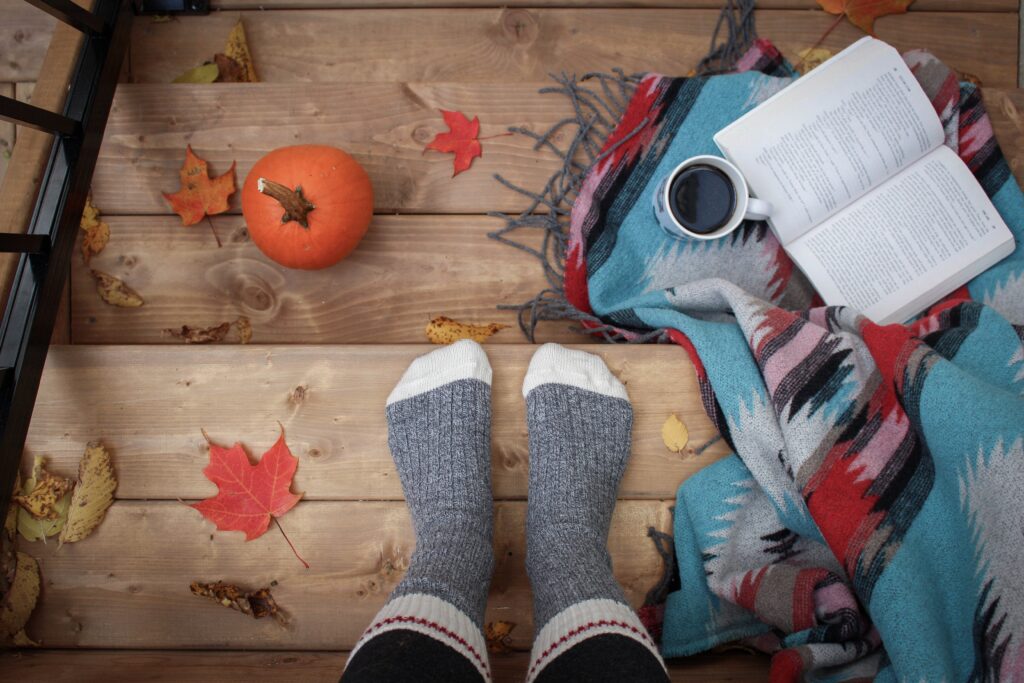 Fall image with book, pumpkin, and socked feet